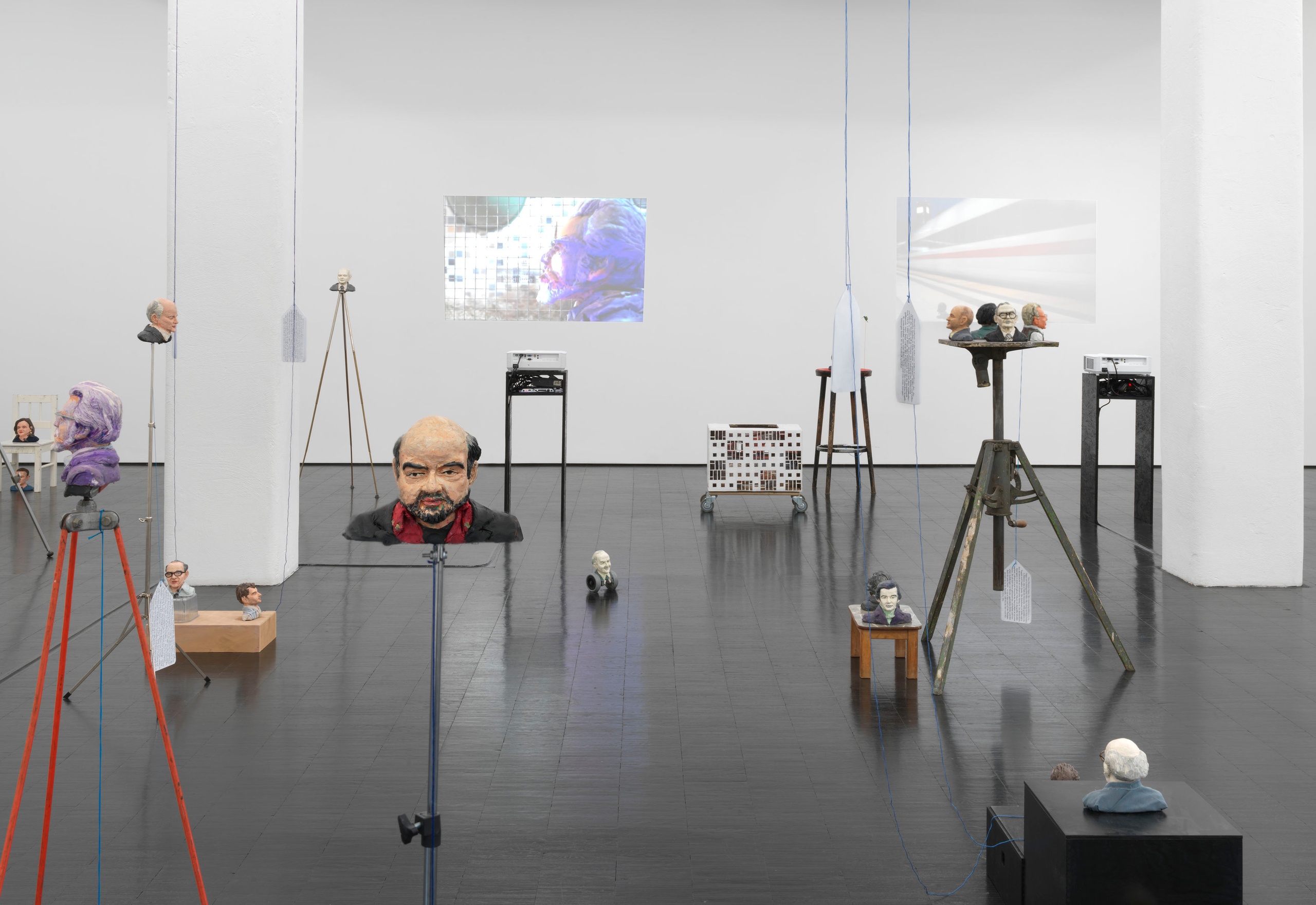 Heads, 2019 - 202147 Plasticine busts, five HD videos (silent, various durations), wallpaper, various materials, dimensions variable